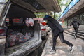 中国中部・湖北省武漢で、住民に届ける野菜を配送車に積み込むスーパーマーケットの従業員（2020年3月5日撮影）。(c)AFP