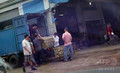 中国・広東（Guangdong）省従化（Conghua）市の卸売市場「幸福市場（Xingfu Market）」で、かごに入った動物をトラックの荷台から降ろす商人たち。車の中から撮影した（2012年8月4日撮影）。(c)AFP