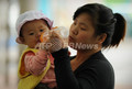 写真は上海（Shanghai）市内で子どもに飲み物を与える母親（2012年5月30日撮影、本文とは関係ありません）。(c)AFP/Peter PARKS