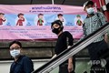 タイ・バンコクの列車の駅で、新型ウイルスに関するポスターの前を通るマスクを着けた乗客（2020年2月1日撮影）。(c)Romeo GACAD / AFP
